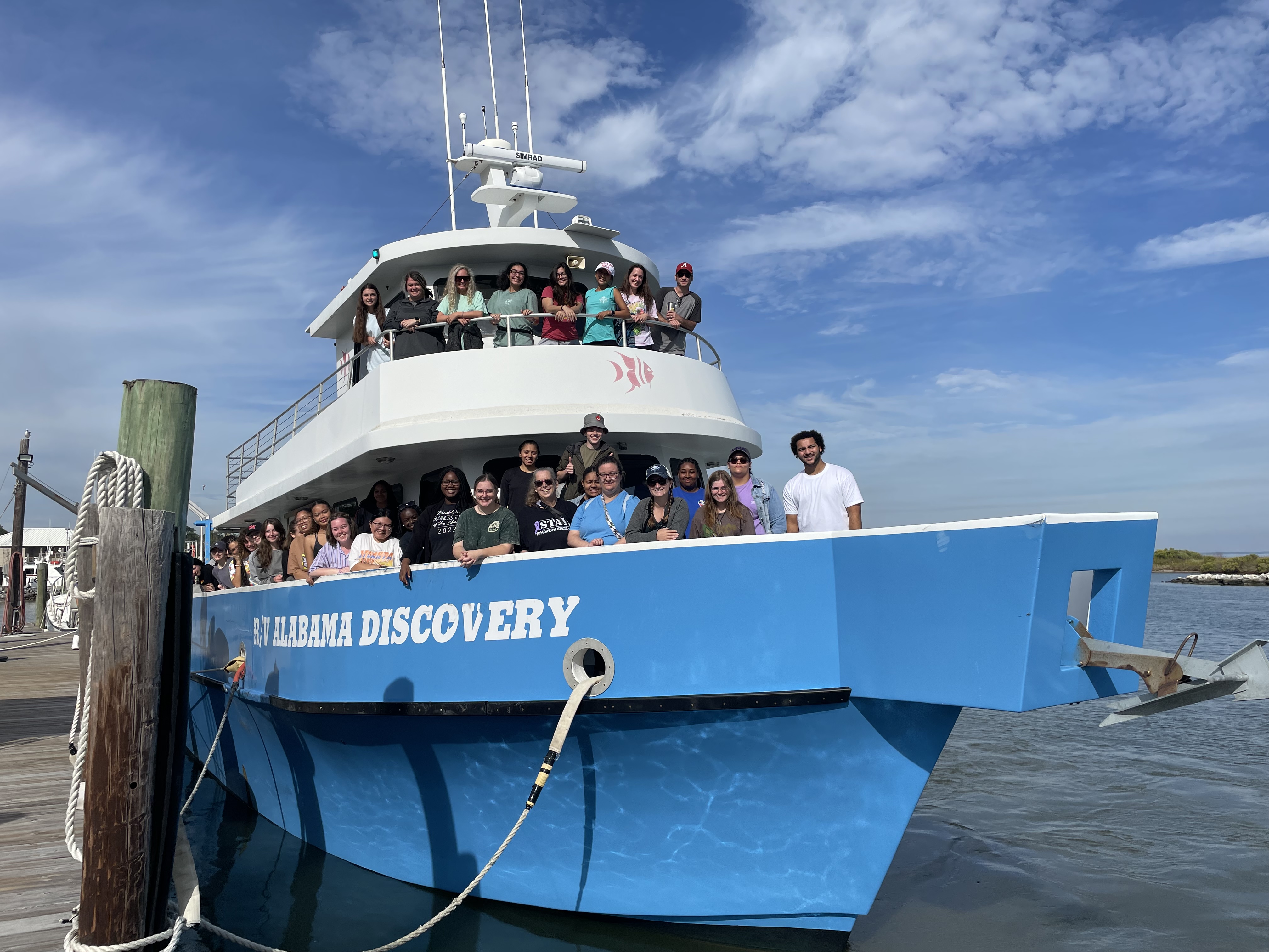 Student group photo on a boat that reads "Alabama Discovery"