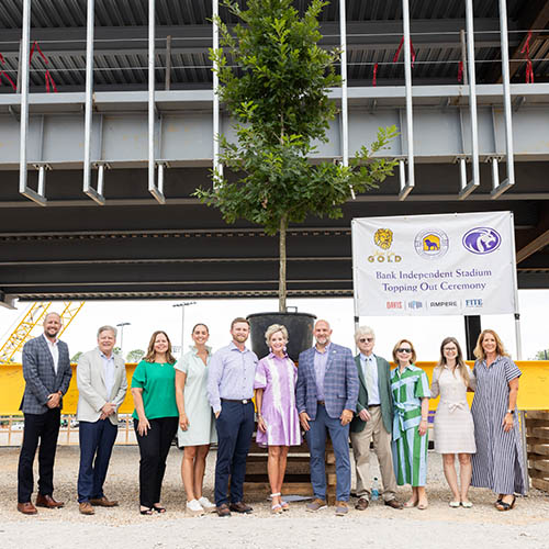 donor group posing in front of signature beam