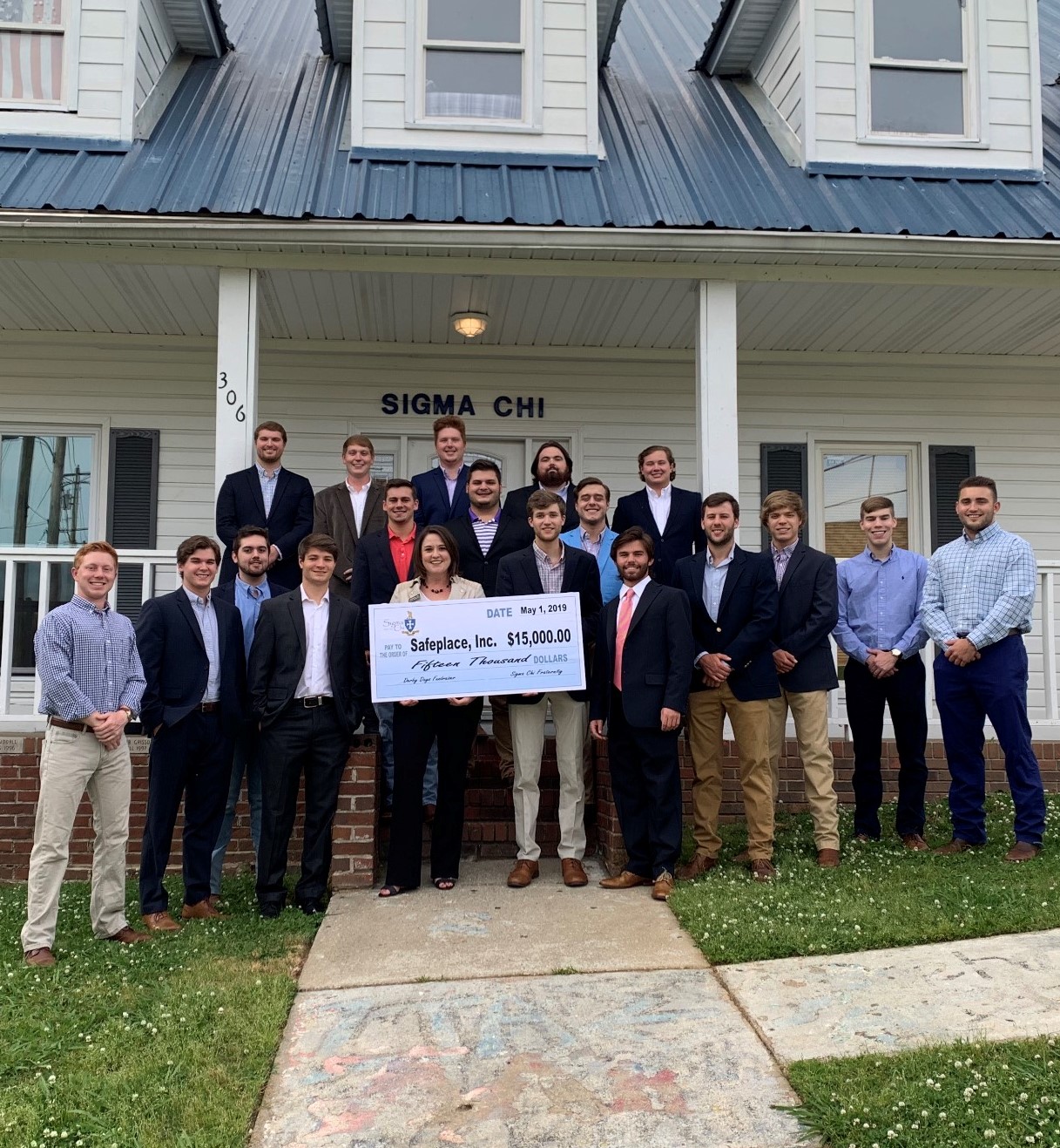 The brothers of sigma chi stand outside their house with a representative from Safe Place, presneting the charity with a $15,000 check from the fraternity's derby days competition.
